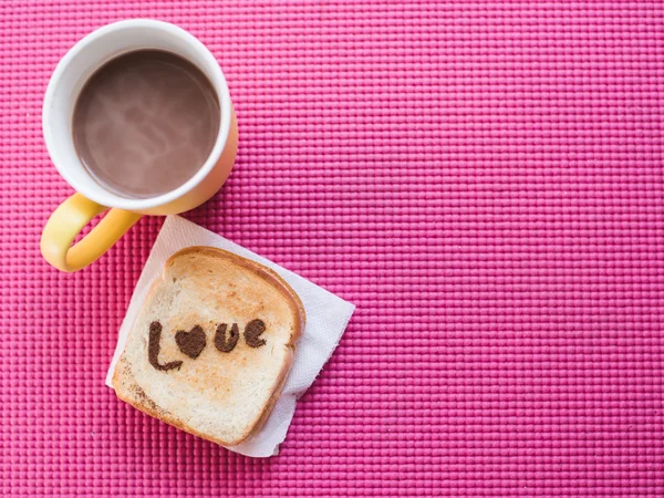 Love message on Bread sliced with and chocolate cup on pink yoga