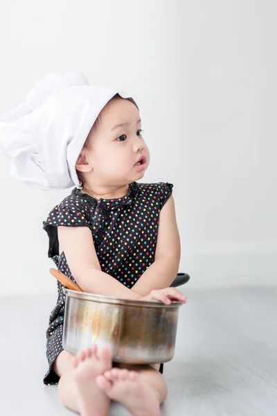 Asian child playing a chef at home.