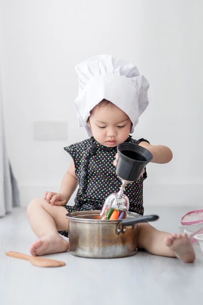 Asian child playing a chef at home.