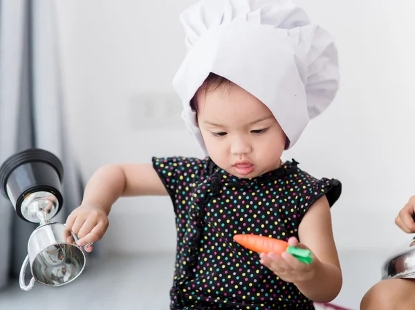 Asian child playing a chef at home.
