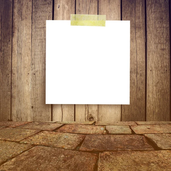 White paper note on the old wooden background