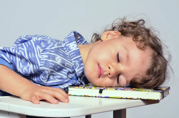 Toddler learning how to write and read. Small kid having fun preparing for school but too tired after a lesson, he went to sleep