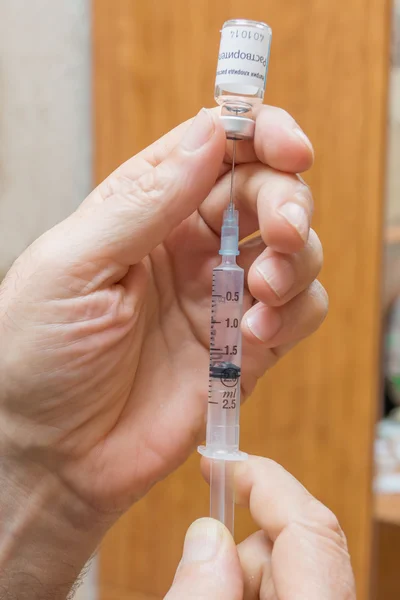 Man picks solution in a syringe to make himself a prick