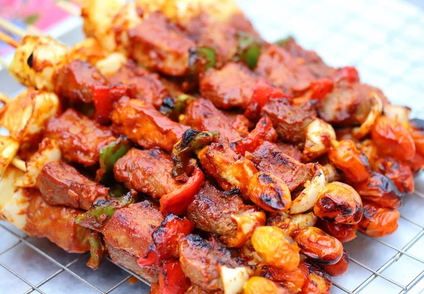 Bar-B-Q or BBQ with kebab cooking. Coal grill of pork skewers with tomatoes, onion and peppers.