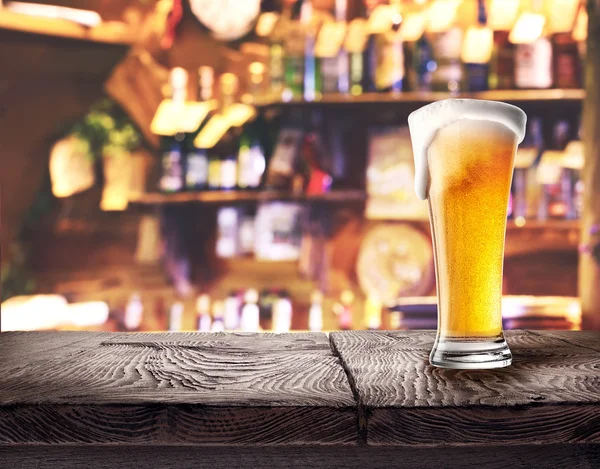 Glass of light beer on wooden board