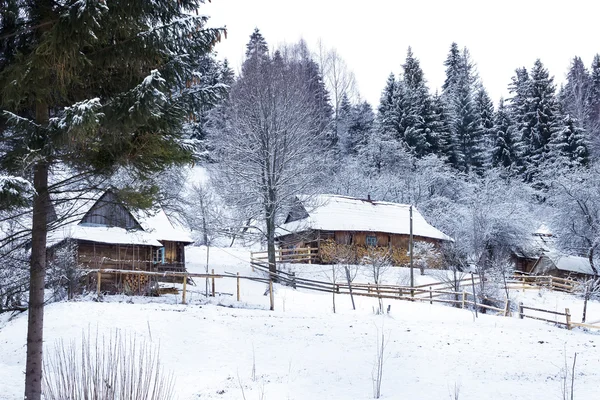 Wooden houses in forest covered with snow