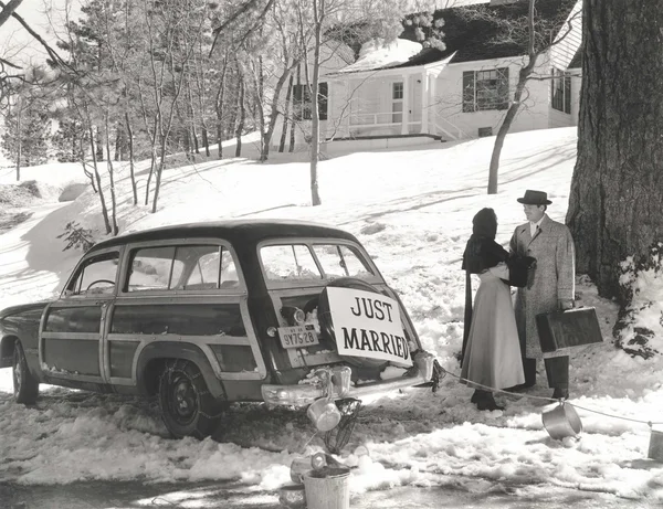 Young couple standing by car