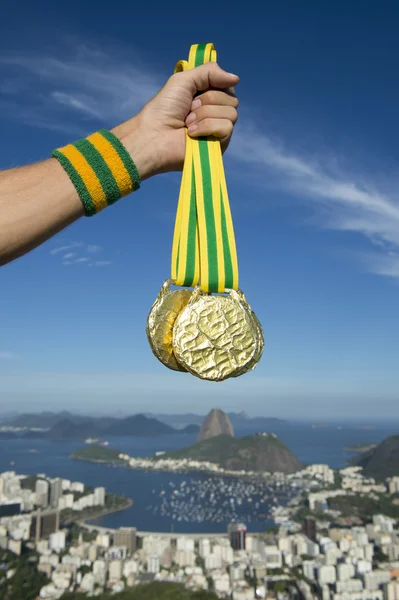 Hand of Athlete Holding Gold Medals Rio Skyline