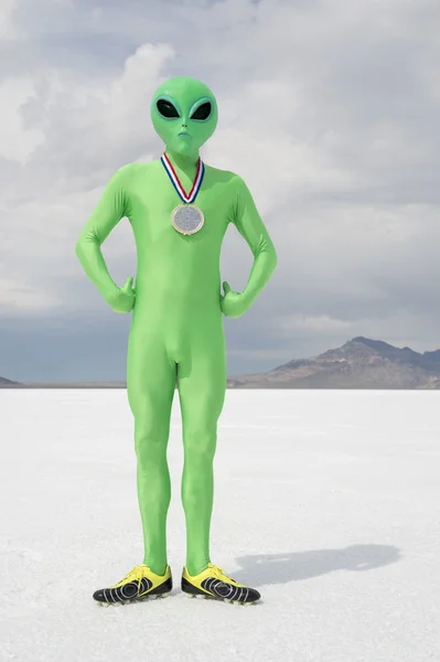 Gold Medal Green Alien Standing on White Planet