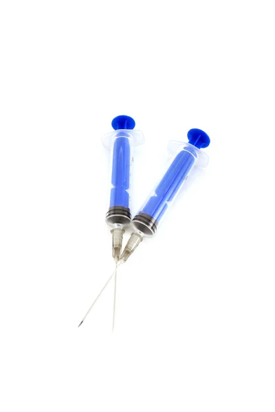 Three pink tablets with a syringe. Isolated object on white back