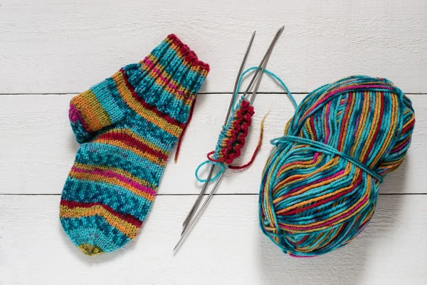 Variegated yarn, sock, needles with knitting