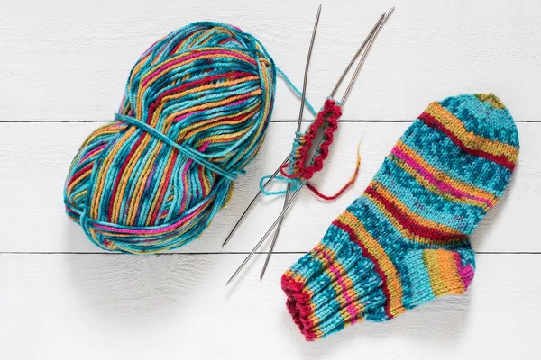 Variegated yarn, sock, needles with knitting