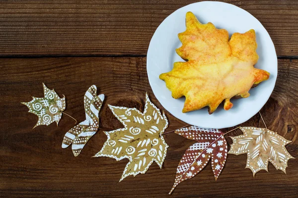 Homemade gingerbread cookie and painted autumn leaves