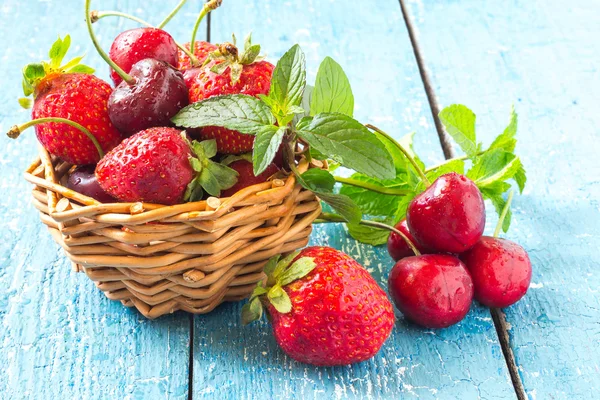Freshly ripe cherries and strawberries in a basket