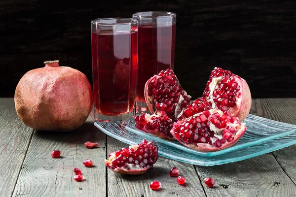 Pomegranate juice and slices of pomegranate with grains