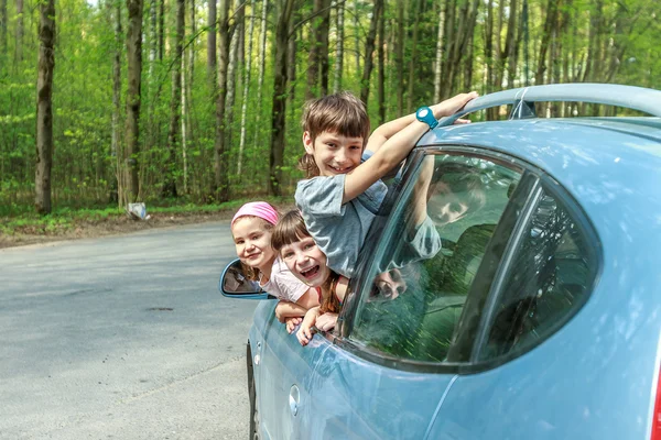 Three happy kids in car, family trip, summer vacation travel