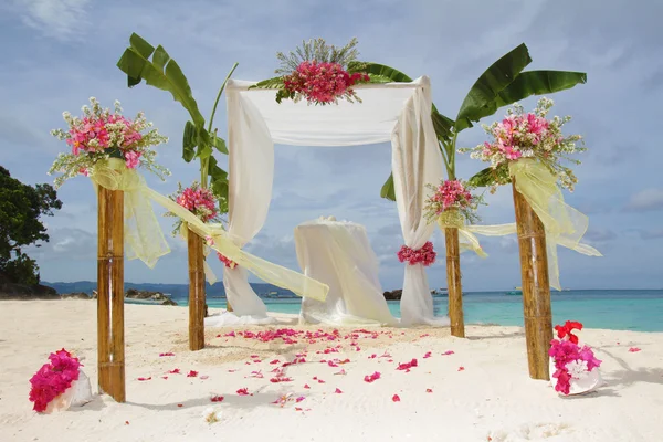 Wedding arch and set up with flowers on tropical beach