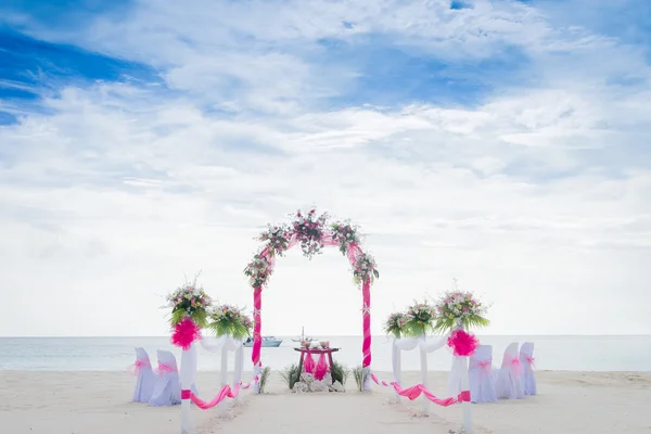 Wedding arch decorated with flowers on beach