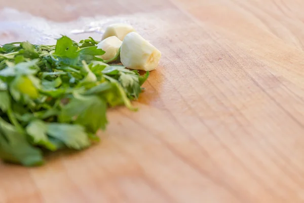 Parsley and garlic on wooden cutting board, cooking time backgro