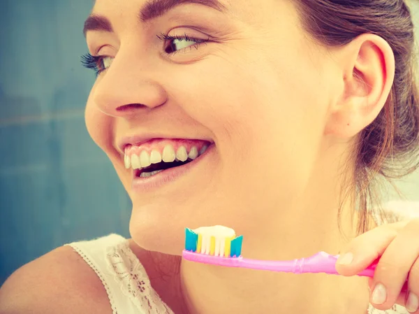 Woman brushing teeth.