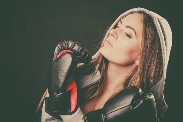Woman with boxing gloves crossed arms.