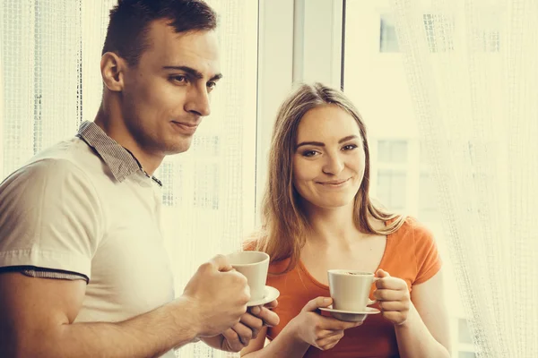 Young couple drinking tea or coffee at home