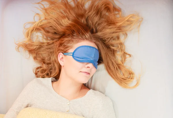 Sleeping woman wearing blindfold sleep mask.