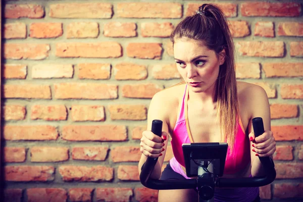 Active woman   using exercise bike