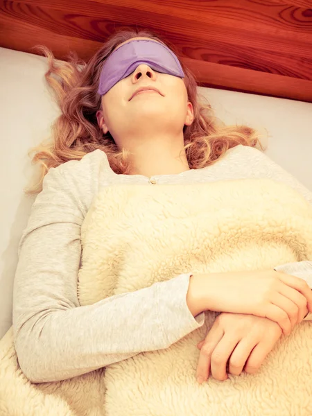 Sleeping woman wearing blindfold sleep mask.