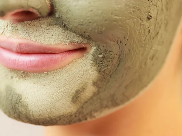 Woman face with green clay mud mask