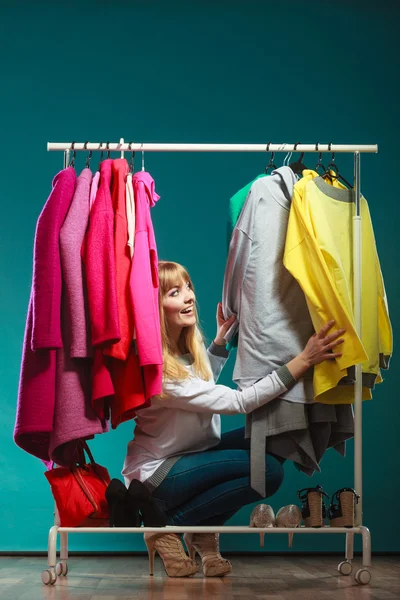 Woman choosing clothes to wear in mall or wardrobe