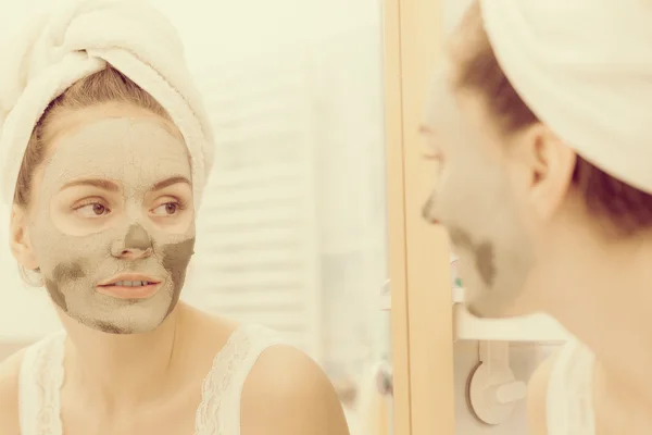 Woman face with green clay mud mask