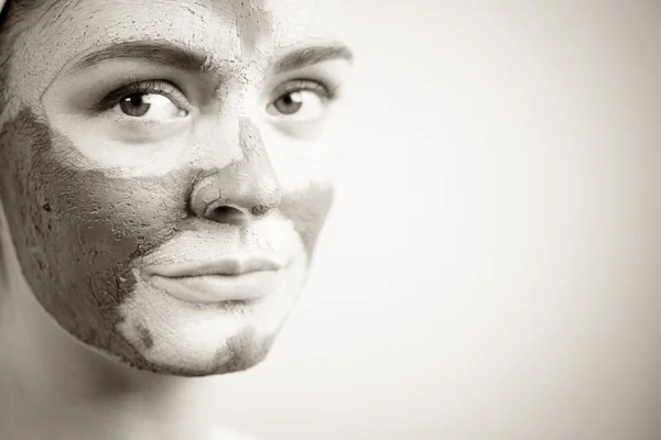 Woman face with green clay mud mask