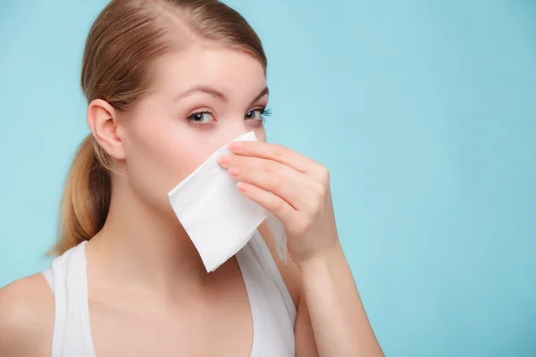 Sick girl sneezing in tissue