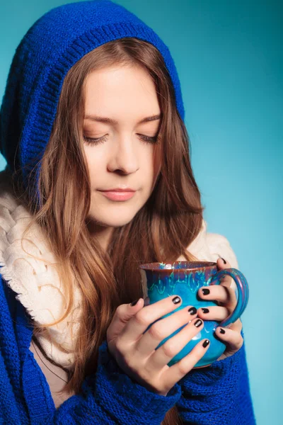 Teen girl holding blue mug with hot drink