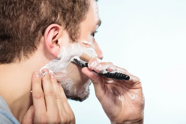 Man shaving with razor face profile