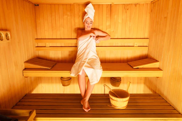 Woman sitting relaxed in sauna