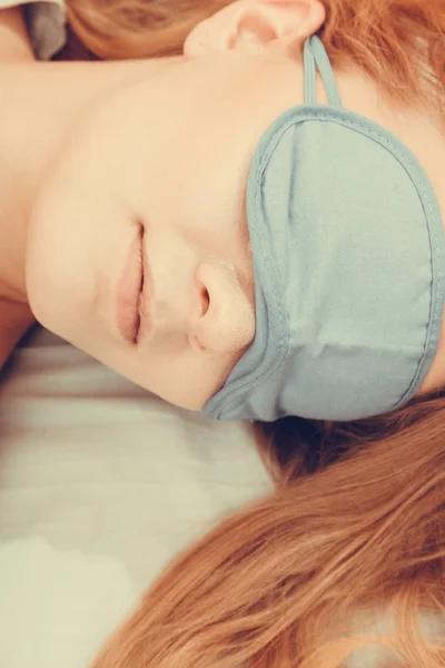 Sleeping woman wearing blindfold sleep mask.