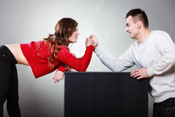 Woman and man arm wrestling