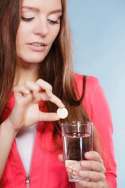 Woman with painkiller pill and water. Health care.