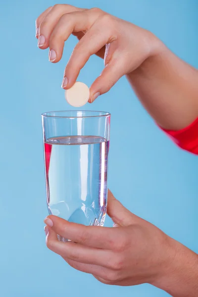 Hands with painkiller pill and water. Health care.