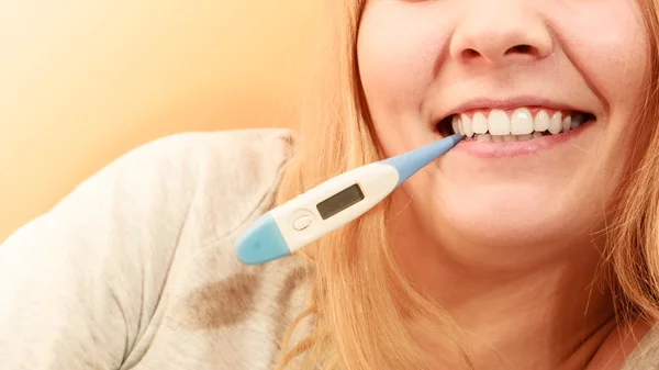 Sick ill woman with digital thermometer in mouth.