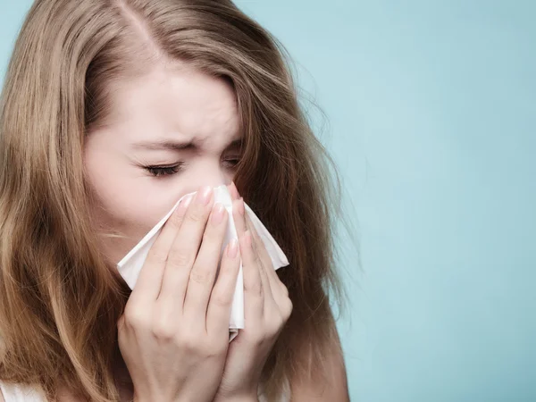 Flu allergy. Sick girl sneezing in tissue. Health