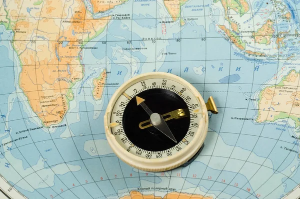 Old compass on vintage map. Retro stale.