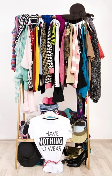 Many clothes on the rack with a t-shirt saying nothing to wear.