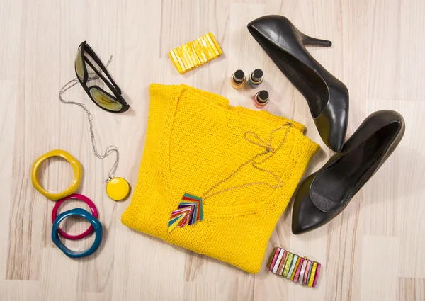 Winter sweater and accessories arranged on the floor.