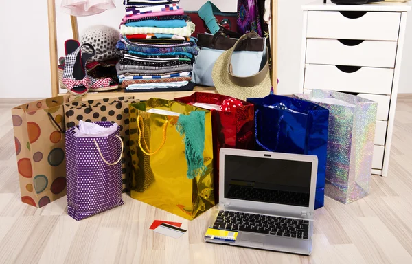 Wardrobe with clothes and shopping bags, on line shopping.