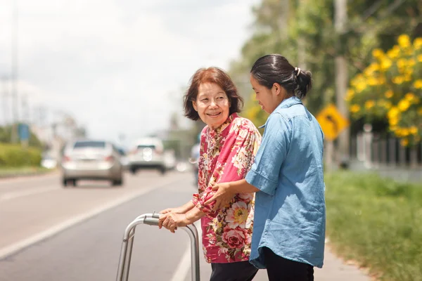 Senior woman using a walker cross street