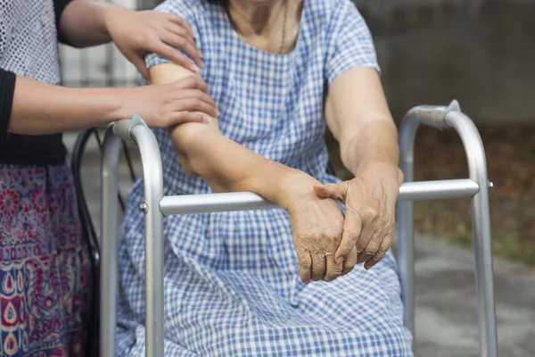 Elderly physical therapy by caregiver in backyard at home