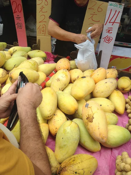 Buyer pays money for mango